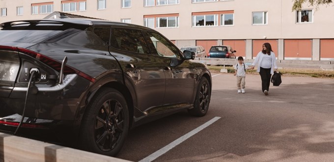 En mamma och son går till elbilen